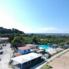 Vista aerea di un complesso con case, piscina e verde attorno.