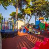 Un parco giochi colorato con altalena, scivoli e giochi per bambini tra gli alberi.