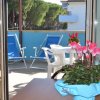 Terrazza con sedie a sdraio blu e un tavolo con fiori rosa.