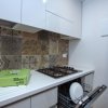 Cucina con piano cottura, lavastoviglie aperta e decorazioni in maiolica.