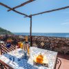 Terrazza con tavolino, vista mare e pergola.