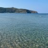Mare cristallino con colline in lontananza.