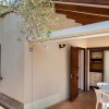 Esterno di una piccola casa con portico e tavolo bianco.