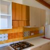 Cucina con fornelli e armadietti in legno.