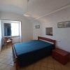 Camera da letto con letto matrimoniale e sedia vicino alla finestra.