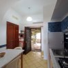 Cucina con tavolo bianco, fornelli e pareti piastrellate blu.