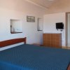 Camera con letto matrimoniale, cassettiera e televisore.