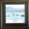 Vista mare da una finestra con barche.