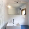 Bagno moderno con specchio grande e lavabo bianco.