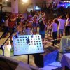 Persone danzano in un'atmosfera festosa, microfono in primo piano.