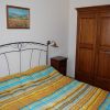 Camera con letto matrimoniale, copriletto a righe, comodini e armadio in legno.