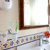 Lavabo in bagno con spazzolini e piastrelle decorate.
