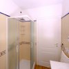 Bagno con doccia e porta bianca.