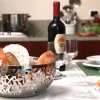 Tavolo apparecchiato con pane e bottiglia di vino.