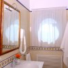 Bagno con specchio ampio e lavabo.