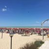 Spiaggia con ombrelloni rossi e lettini.
