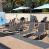 Lettini e ombrelloni vicino a una piscina.