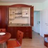 Cucina moderna con tavolo rotondo e sedie rosse.