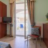 Stanza con balcone e tende, sedia con cuscino decorativo.