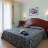 Letto matrimoniale con copriletto blu a motivi floreali.