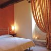 Camera da letto con tenda a righe e illuminazione calda.