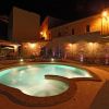 Piscina illuminata di notte con mura di mattoni.