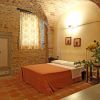 Camera da letto con pareti di mattoni e fiori sul tavolo.