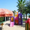 Area giochi con scivolo colorato in spiaggia.