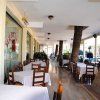 Terrazza di ristorante con tavoli e palme.