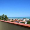 Vista panoramica di case e mare sotto cielo blu.