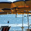 Ombrelloni gialli e blu sulla spiaggia con vista mare.