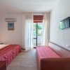 Camera con letto matrimoniale e divano rosso.