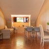 Interno con area pranzo, tavolo e sedie, illuminato da una finestra con vista sugli alberi.