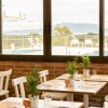 Sala da pranzo con vista su piscina e montagne sullo sfondo.