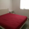 Stanza con letto matrimoniale e lenzuolo rosso.