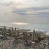 Spiaggia con ombrelloni e lettini al tramonto.