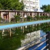 Lungo canale d'acqua con alberi verdi e edificio sullo sfondo.
