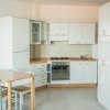 Cucina bianca moderna con tavolo e sedie.