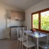 Cucina compatta con tavolo bianco e sedie.