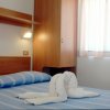 Letto con lenzuola a righe blu e asciugamani a forma di cigno.