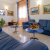 Salotto con divani blu, tavolini e quadri alle pareti.