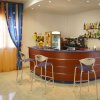 Bar d'albergo con bancone curvo, sedie alte e alcolici esposti.