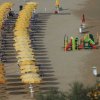 Spiaggia con file di ombrelloni gialli e un'area giochi per bambini.