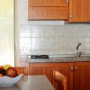 Una cucina con mobili in legno e un tavolo con un cesto di frutta.