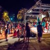 Spettacolo notturno all'aperto con pubblico seduto e in piedi davanti a un palco.