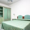 Letto matrimoniale verde con armadio e porte turchesi.