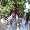 Famiglia che passeggia in un parco verde.