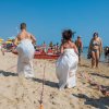 Corsa nei sacchi su una spiaggia affollata.