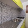 Cucina con mosaico e mobili gialli.