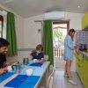 Famiglia in cucina luminosa con mobili verde lime.